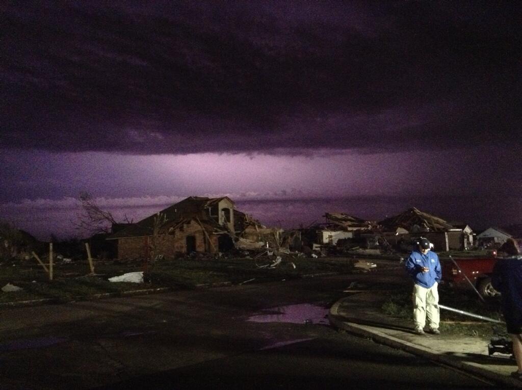 Lightning lights up the sky over a Weather Channel live broadcast the night after the tornado